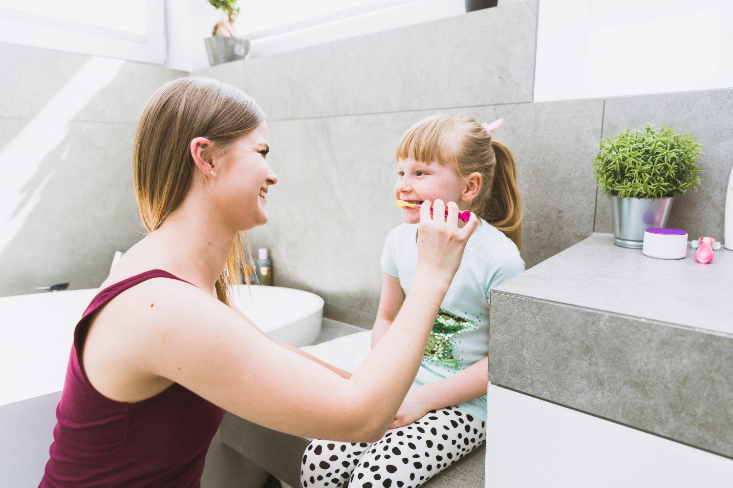 Mutter putzt der kleinen Tochter die Zähne