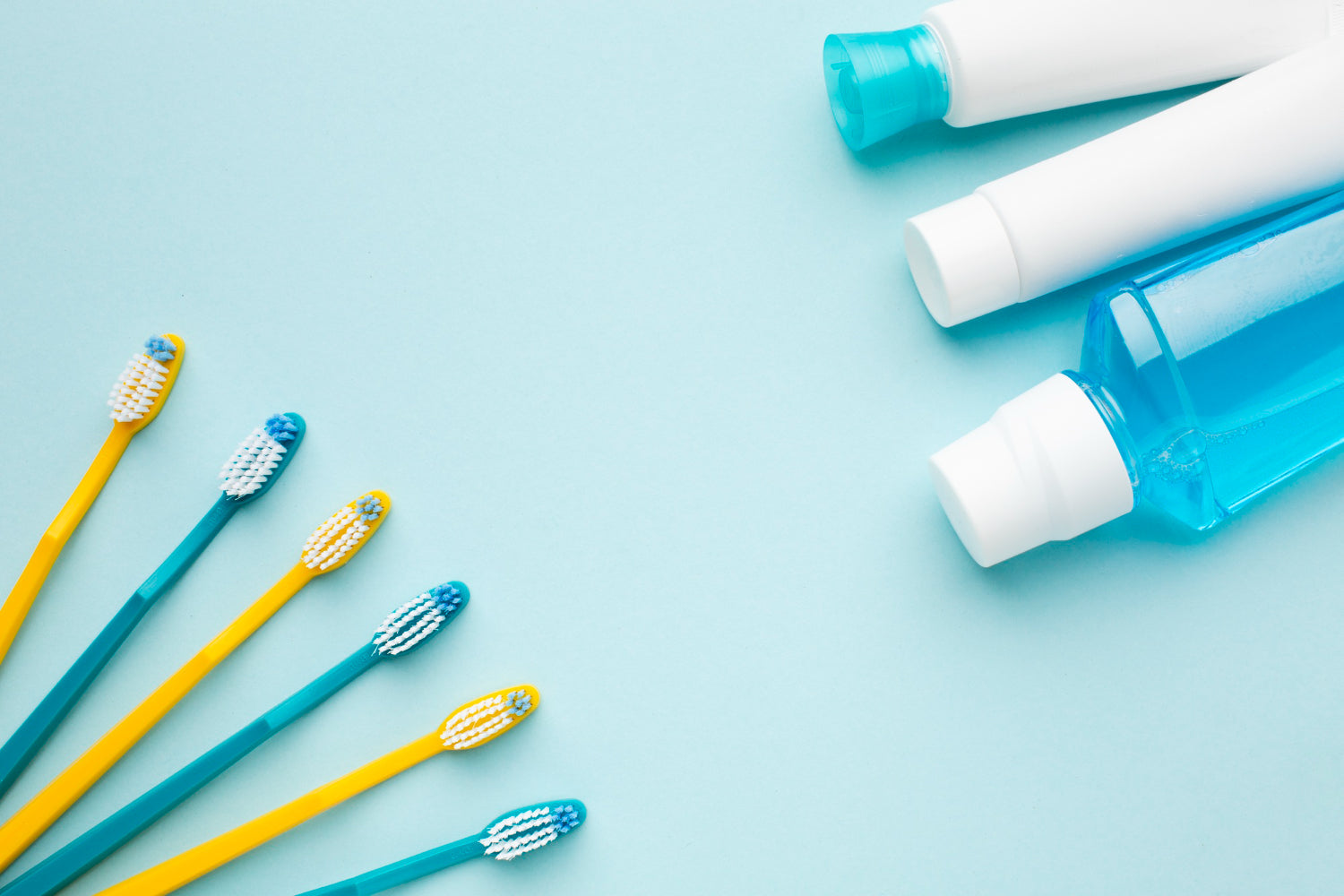 Zahnbürsten und andere Hygiene Produkte auf blauem Hintergrund