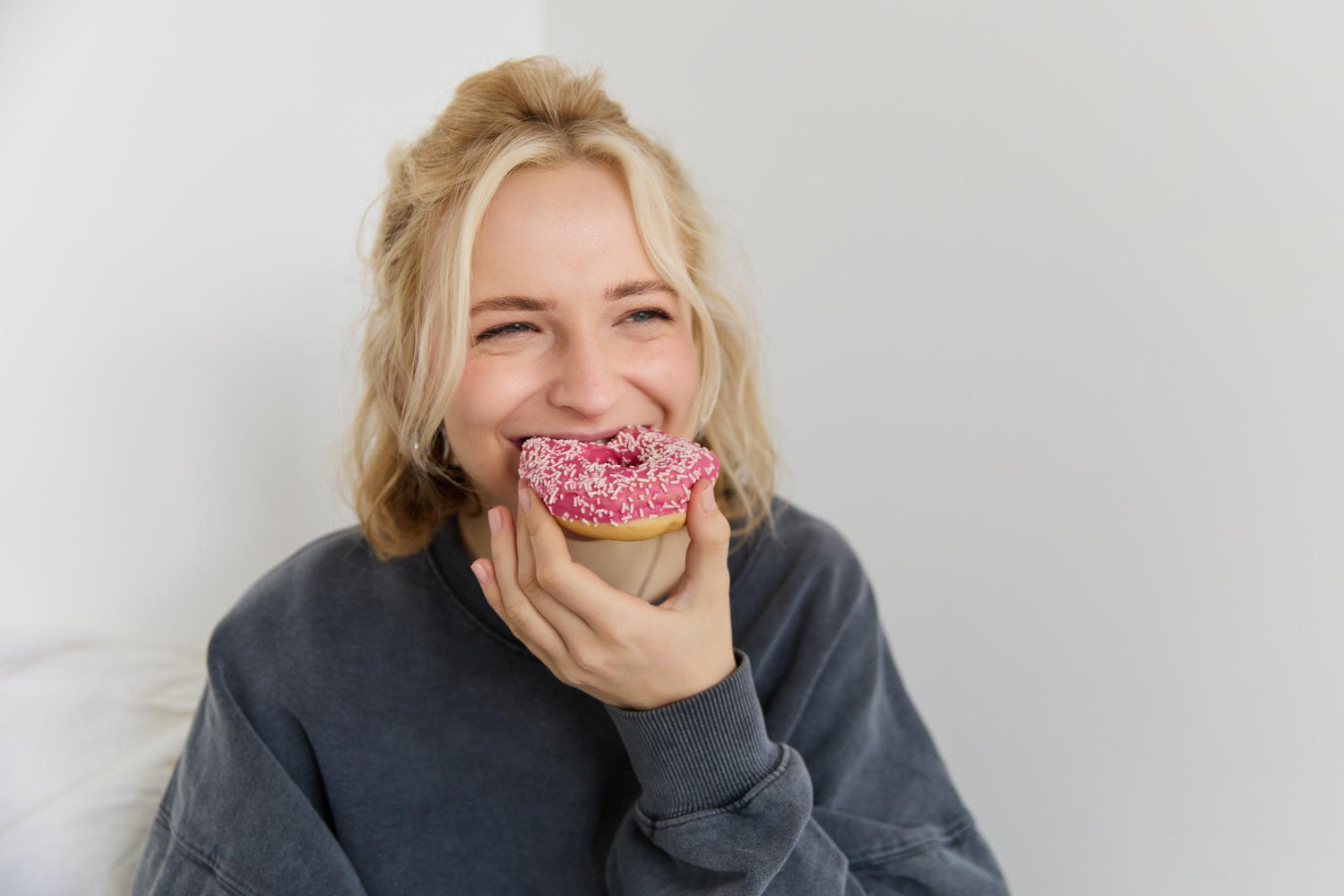 blonde Frau isst einen süßen Donut