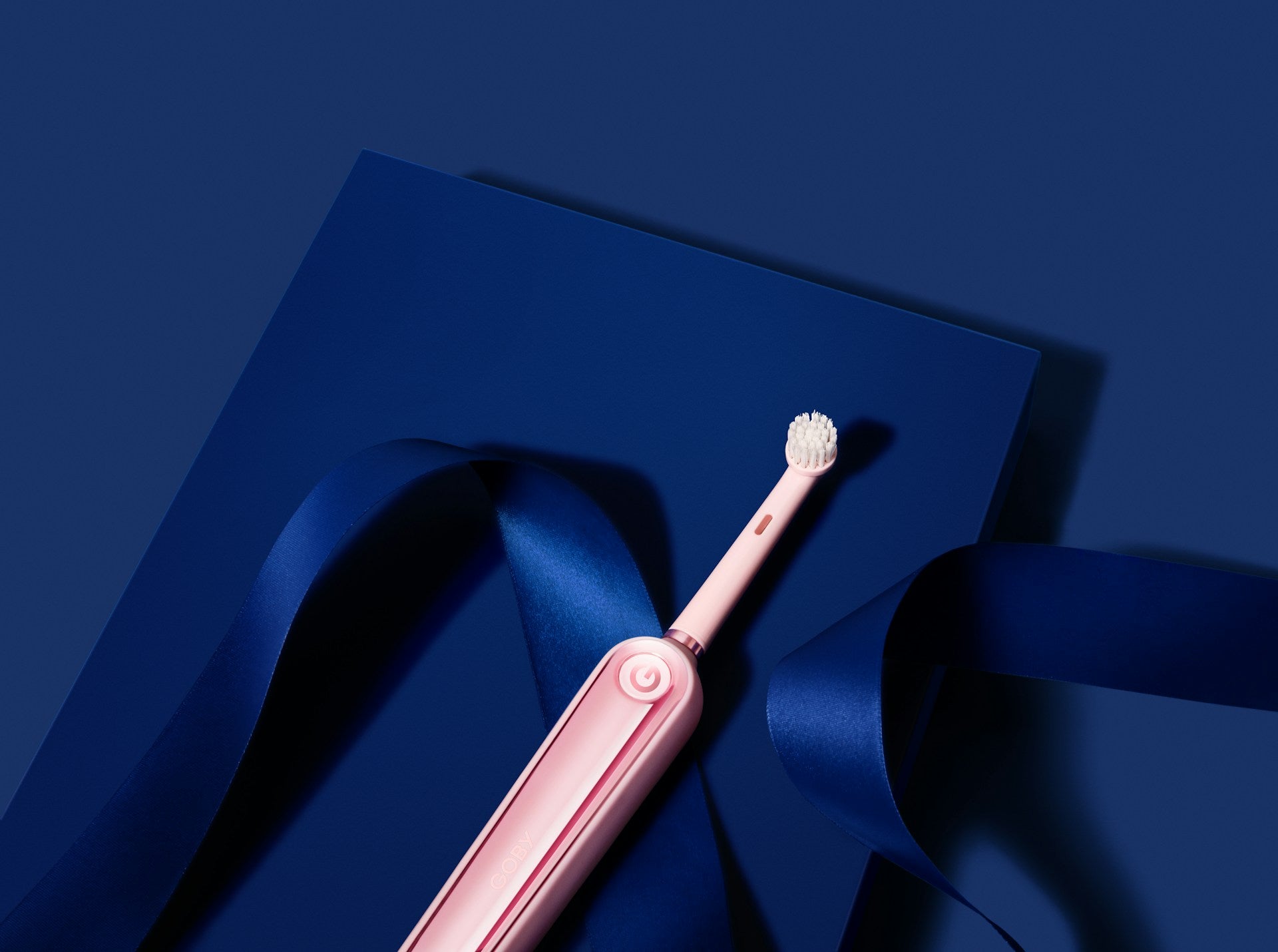 Pink elektrische Zahnbürste auf blauem Hintergrund